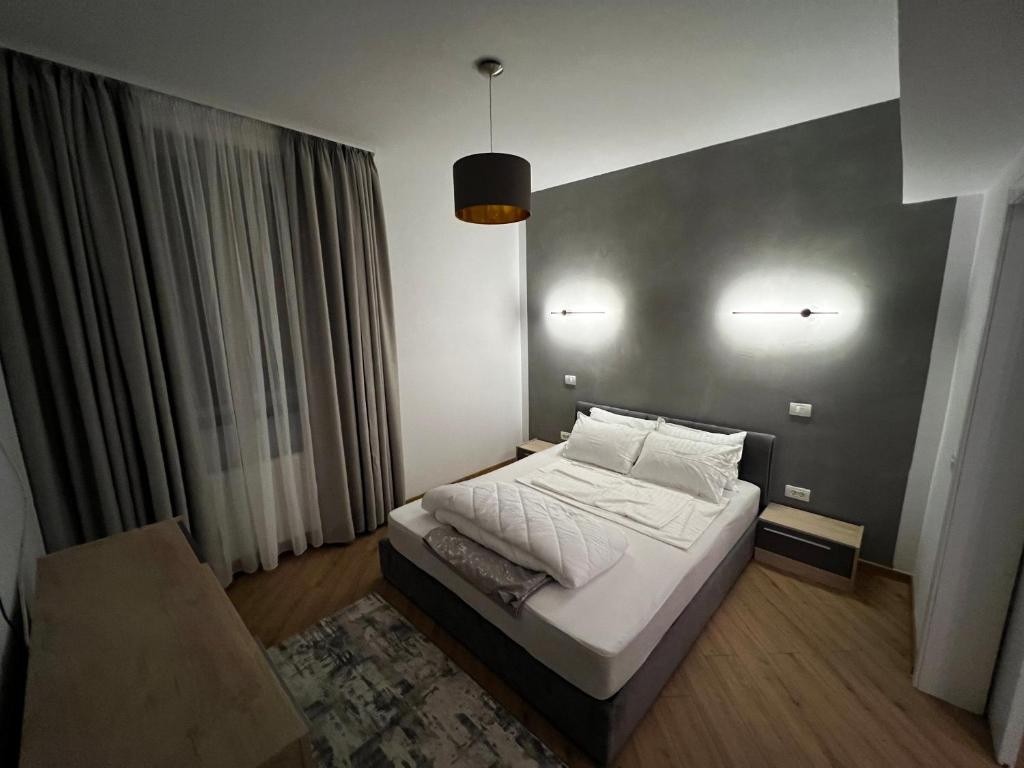 Dormitorio pequeño con cama y pared gris en Neversea Suite en Constanza