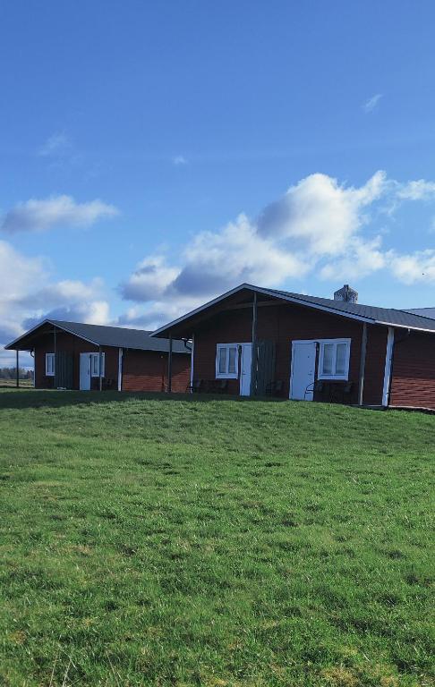 a group of buildings on a grass field at Stuga utanför Skövde 3 in Skövde