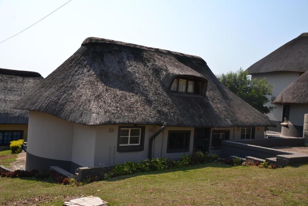 a thatched house with a grass roof at 3 Anchors Aweigh in Hibberdene