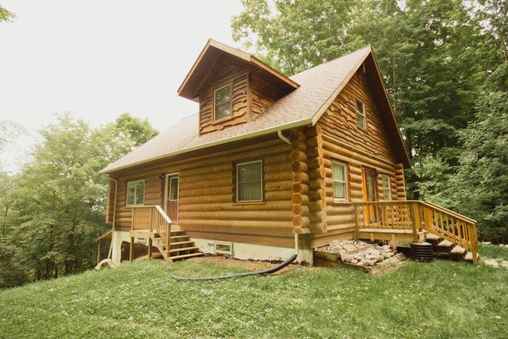 a log cabin with a porch and a deck at Wilderness Vista Retreat in Reed City