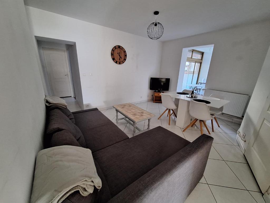 sala de estar con sofá y mesa en Le-bon-appart de plain-pied avec terrasse, en Auxonne