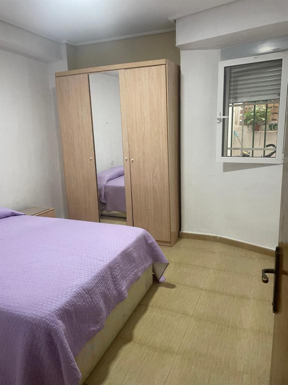 a bedroom with a purple bed and a window at Habitación privada in Valencia