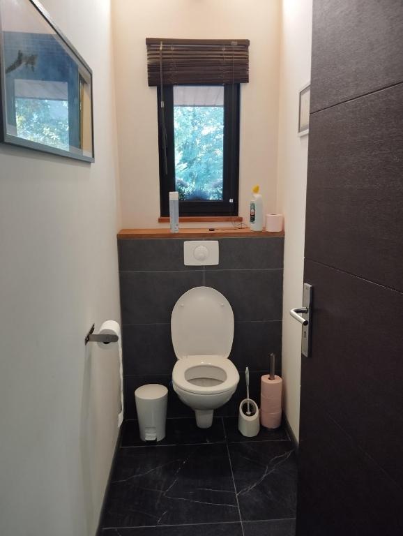 a small bathroom with a toilet with a window at VILLA KB&#39;HOME in Le Touquet-Paris-Plage