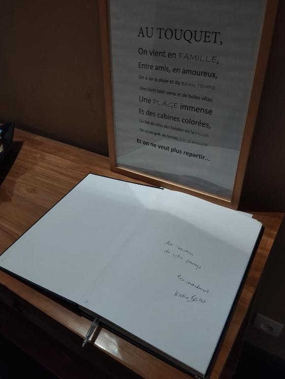 a white piece of paper on a table with a sign at VILLA KB&#39;HOME in Le Touquet-Paris-Plage