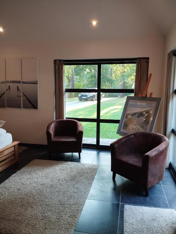 a living room with two chairs and a large window at VILLA KB&#39;HOME in Le Touquet-Paris-Plage