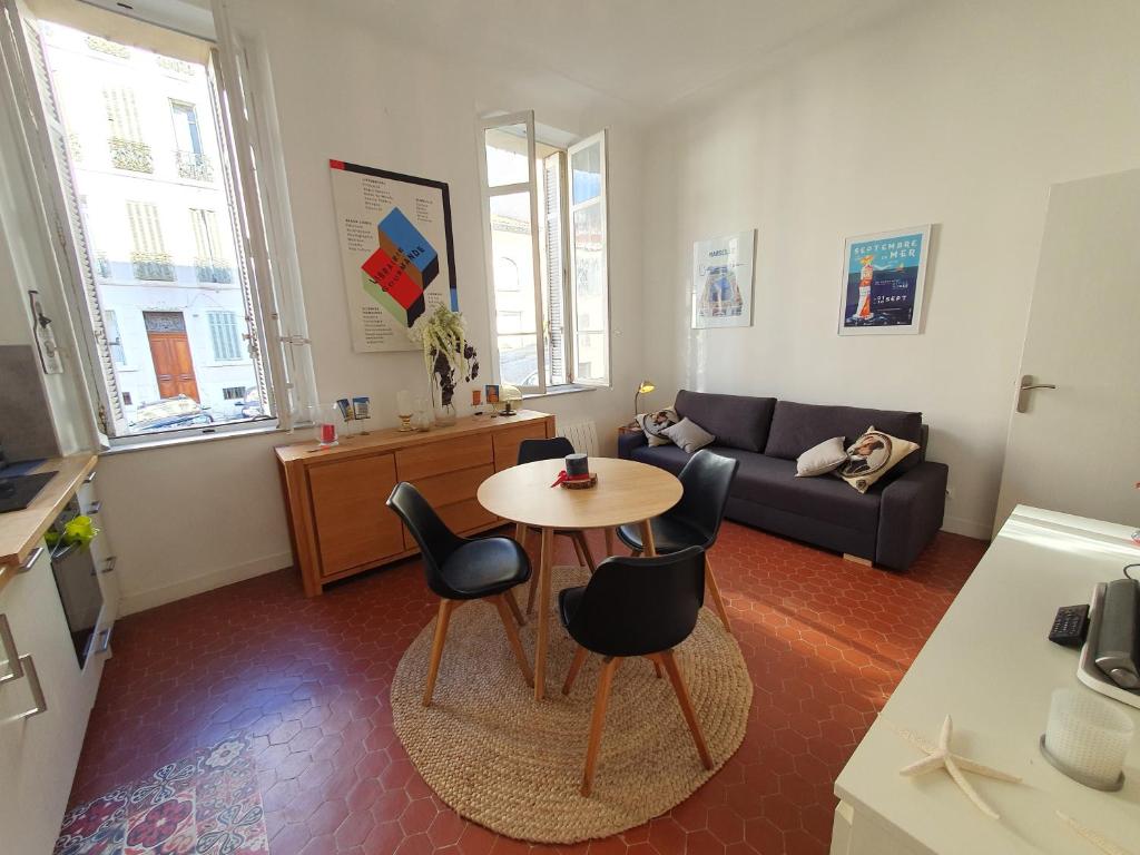 un salon avec une table, des chaises et un canapé dans l'établissement Les hauts d aune, à Marseille
