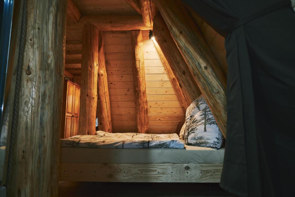 un piccolo letto in una baita di tronchi con finestra di Domček v pieninach . a Majere