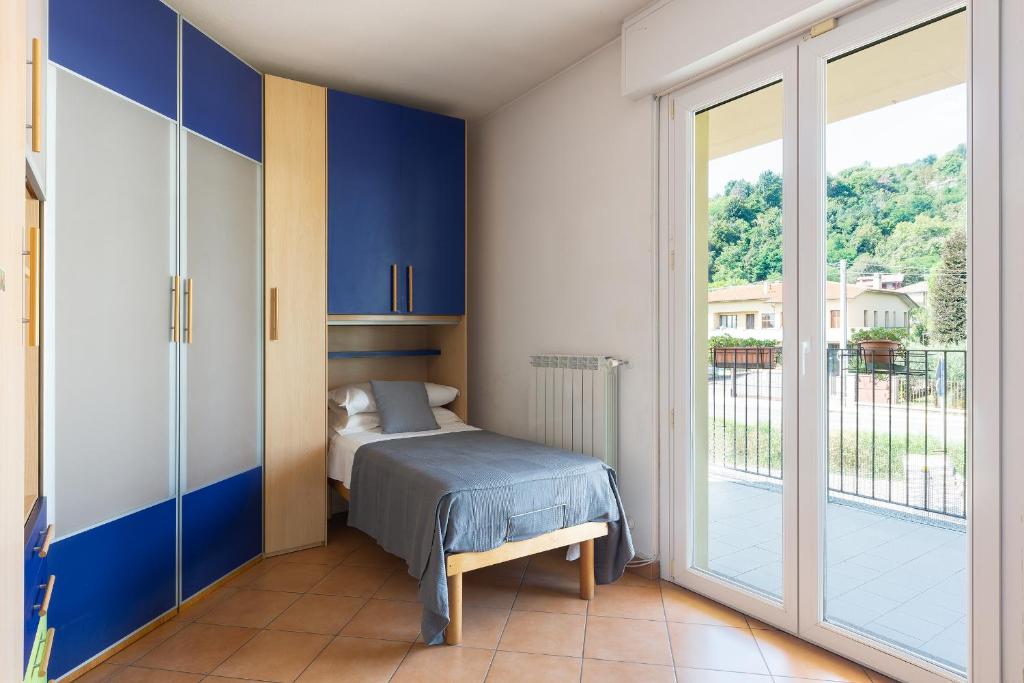a bedroom with a bed and a sliding glass door at Una Finestra Sulle Montagne in Albavilla