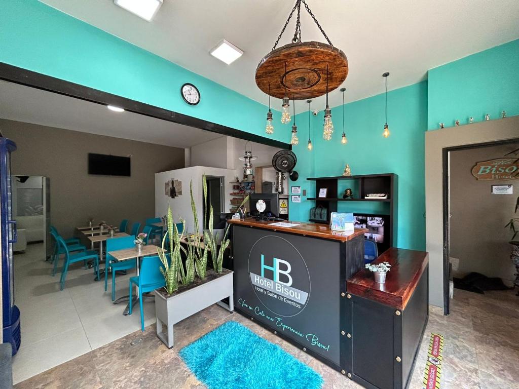 ein Restaurant mit blauen Wänden sowie einem Tisch und Stühlen in der Unterkunft Hotel Bisou in Cali