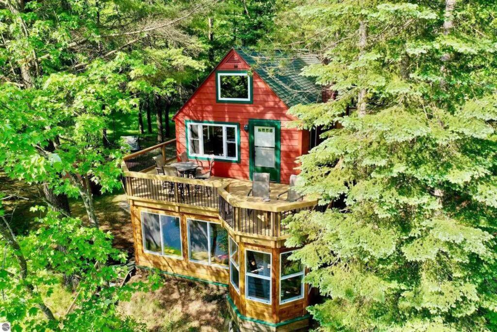 an aerial view of a red house in the woods at Wildlife Haven Retreat in Evart