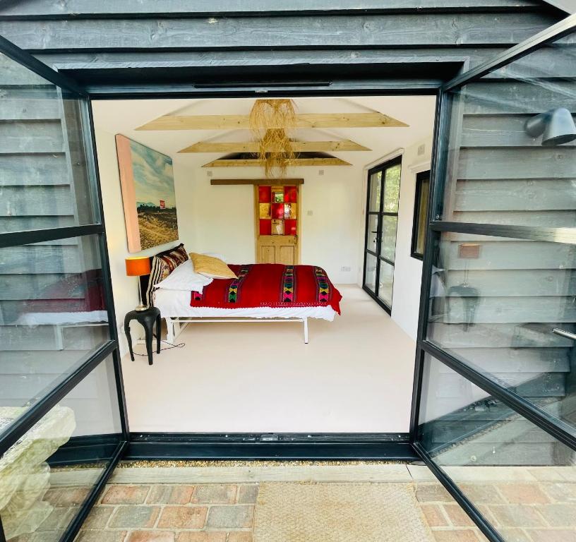 a view of a bedroom from inside a glass house at High spec studio cabin-Farnham centre in Farnham