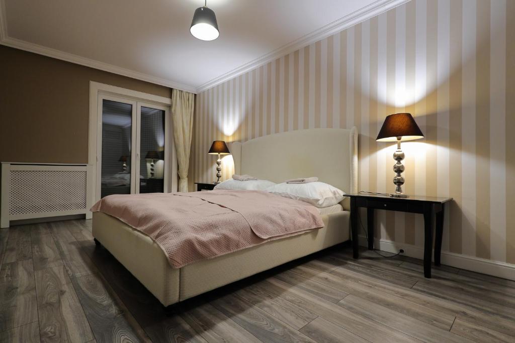LOFT APARTAMENT II NAMYSŁÓW في ناميسلوف: غرفة نوم بسرير وطاولة ومصابيح