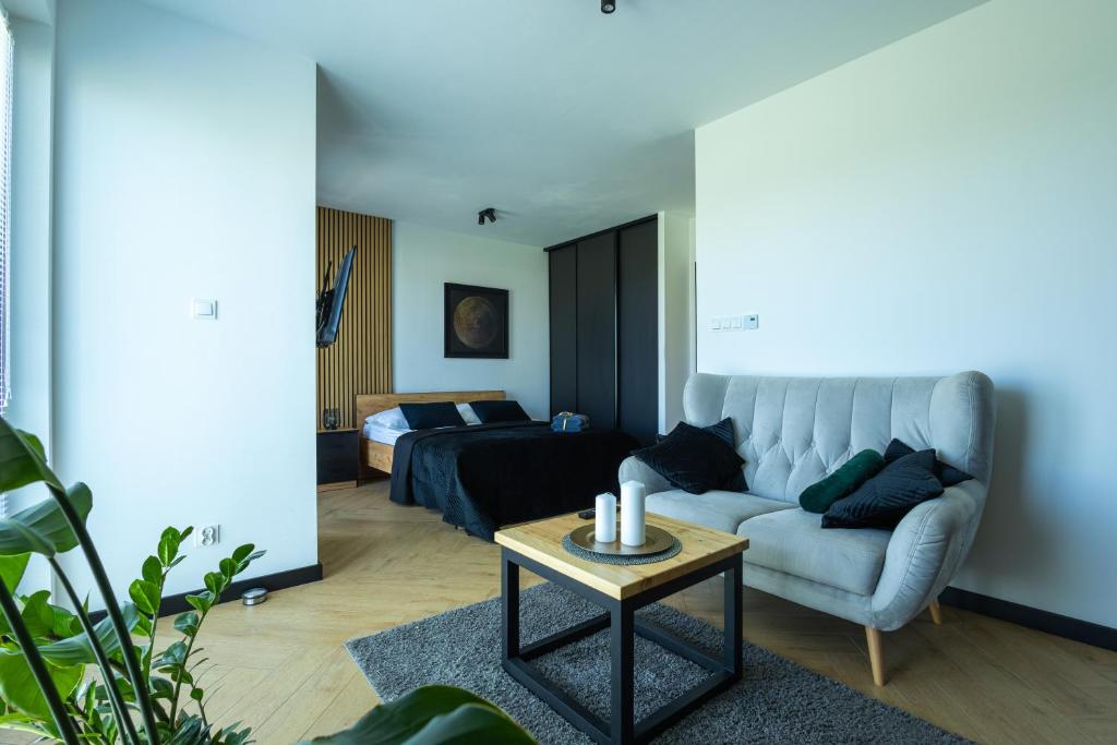 a living room with a couch and a bed at Vip Apartamenty in Rzeszów