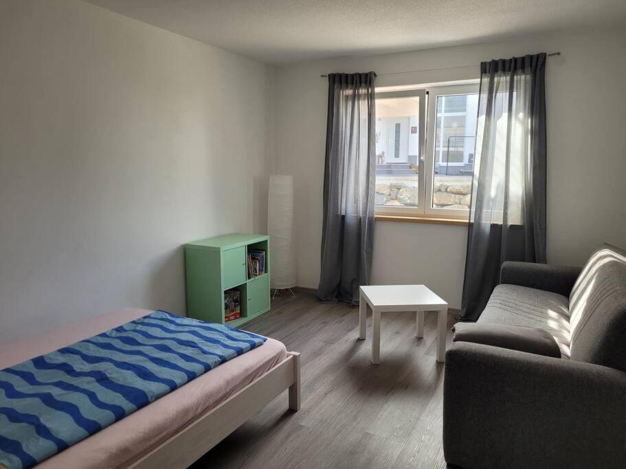 1 dormitorio con cama, sofá y ventana en Ferienwohnung Häring, en Aitrang