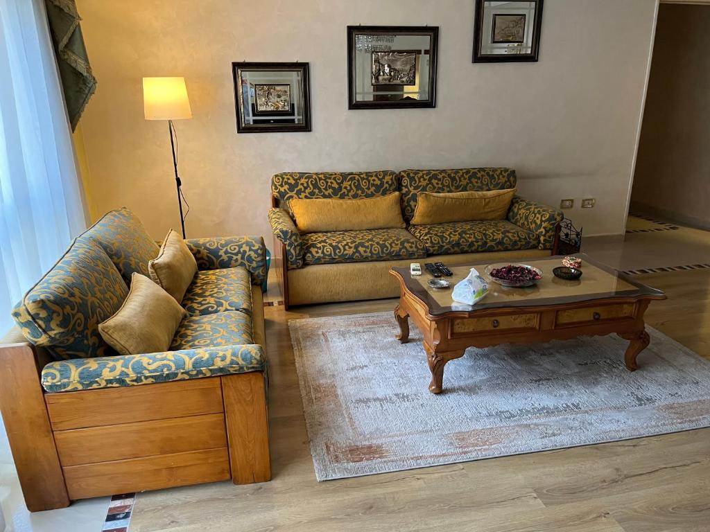 Sala de estar con 2 sofás y mesa de centro en Lovely furnished 2-bedroom apartment with balcony en El Cairo