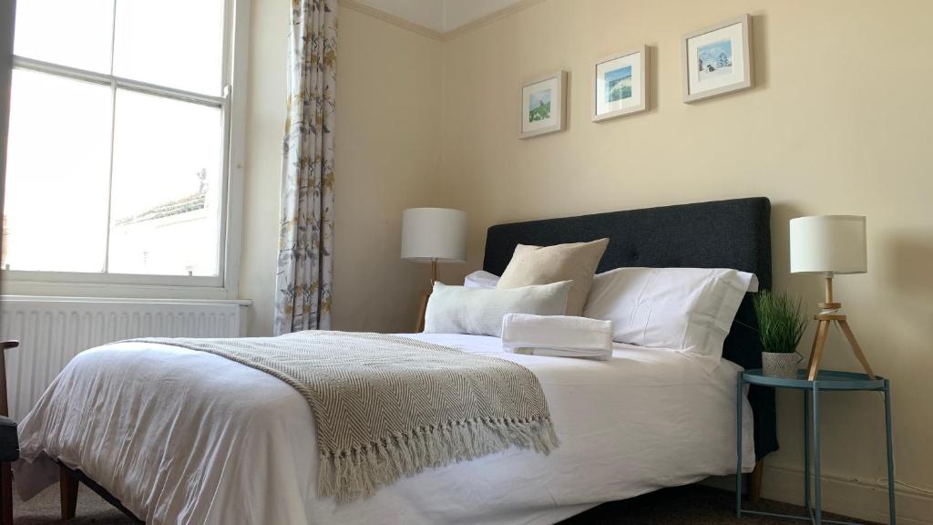 a bedroom with a large white bed with a window at Townhouse II in Plymouth