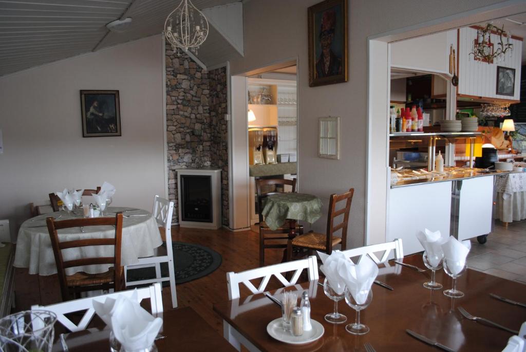a dining room with a table and a kitchen at Haltinmaa Cottages in Kilpisjärvi