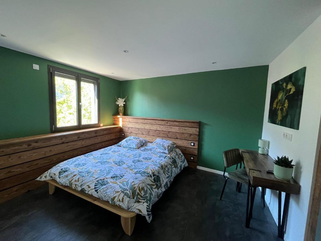 a bedroom with a bed and a desk and a window at Le Cristal Montvernier in Montvernier