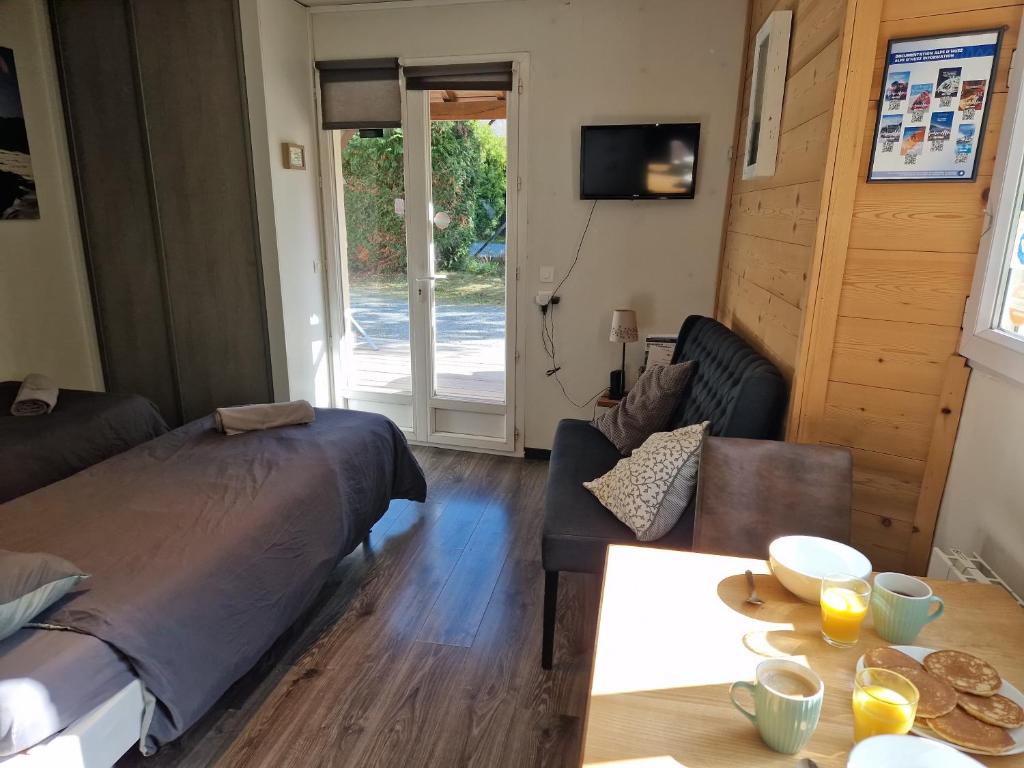 Pokój z łóżkiem, kanapą i stołem w obiekcie Studio La Cabane Centre Ville w mieście Le Bourg-dʼOisans
