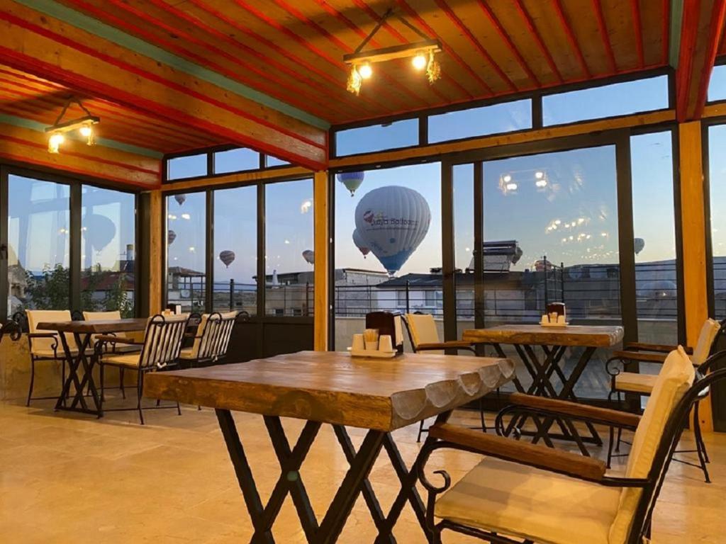 ein Restaurant mit Tischen und Stühlen und einem Ballon am Himmel in der Unterkunft Rustic Caves Hotel in Goreme