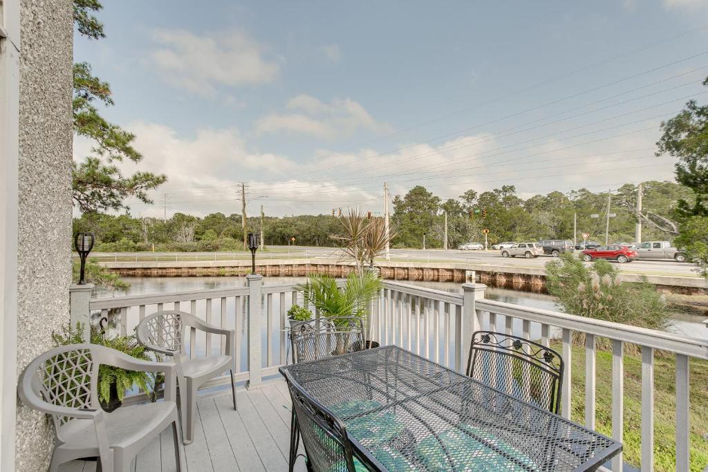 a patio with a table and chairs on a balcony at Coastal St Simons Retreat Near Gascoigne Bluff! in Saint Simon Mills