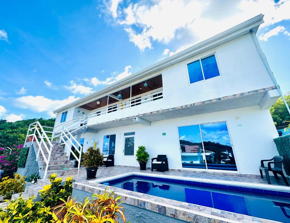 a house with a swimming pool in front of it at Posada Lkjay Providencia Isla in Providencia