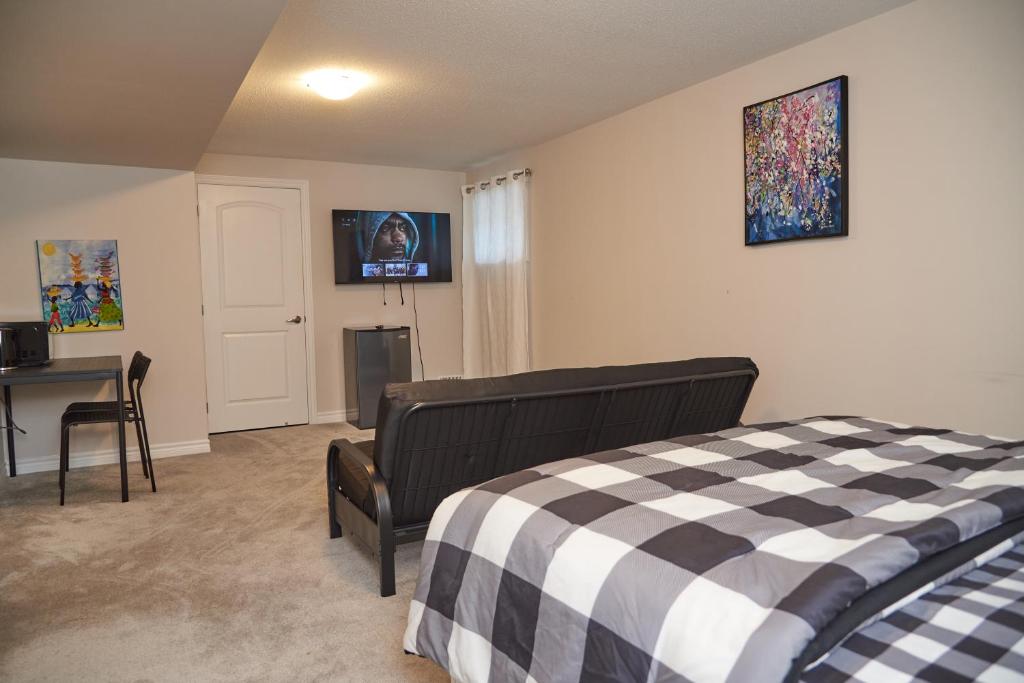 a bedroom with a bed and a desk and a television at Fully Furnished En-Suite Basement in Ottawa