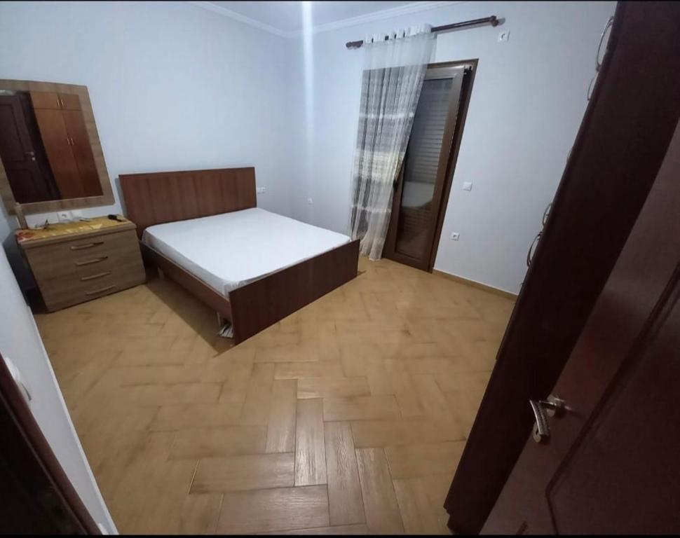 - une petite chambre avec un lit et du parquet dans l'établissement Relax, à Elbasan