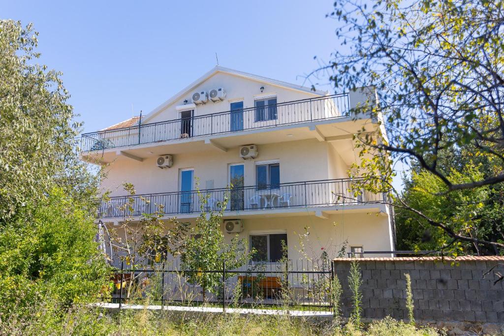 un edificio bianco con balcone sopra di Apartments Lustica a Tivat