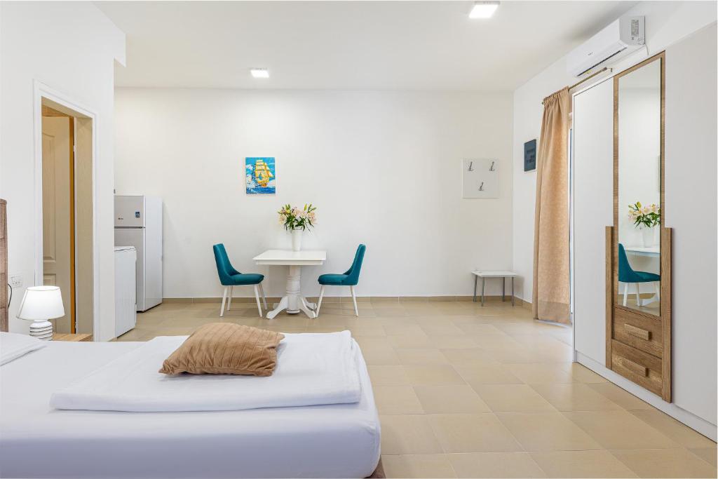 um quarto com uma cama, uma mesa e cadeiras em Apartments Lustica em Tivat