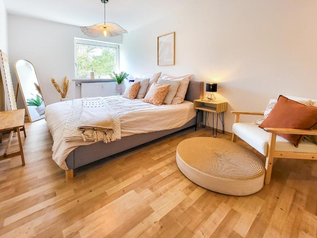 a bedroom with a bed and a couch and a chair at Stilvolle 3-Zimmer Wohnung in Ingolstadt mit Balkon und guter Autobahnanbindung in Ingolstadt