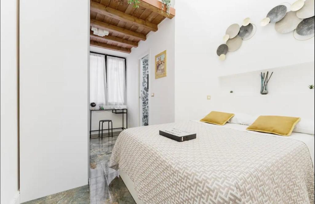 um quarto branco com uma cama grande e almofadas amarelas em Pav Suite Rome em Roma