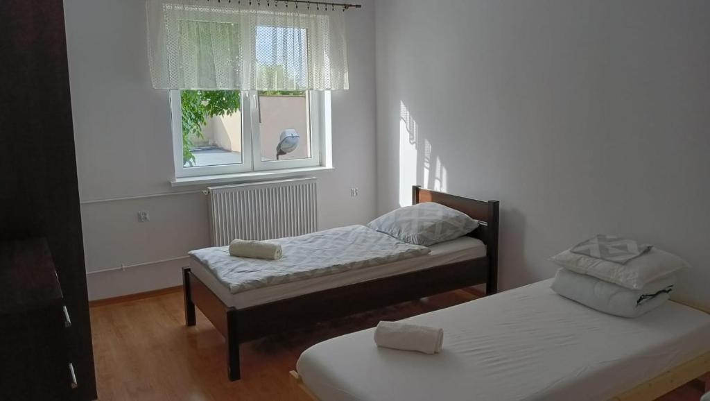 - une chambre avec 2 lits et une fenêtre dans l'établissement Pokoje_Zbąszyń, à Zbąszyń