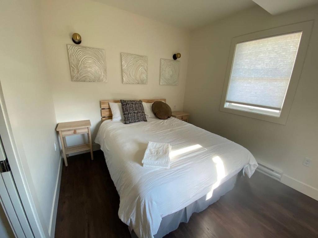 a bedroom with a white bed and a window at Brand New 1 Br 1 Bath Close To All Walkable in Edmonton