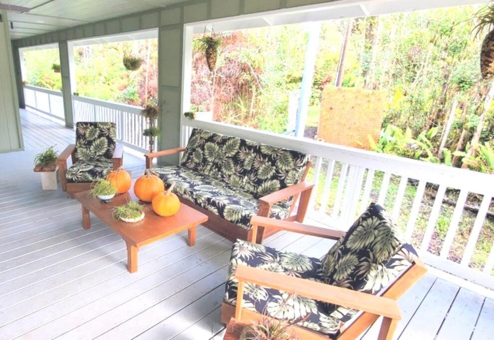 a porch with a couch and two chairs and a table at Private House Located between Volcano and Hilo in Mountain View