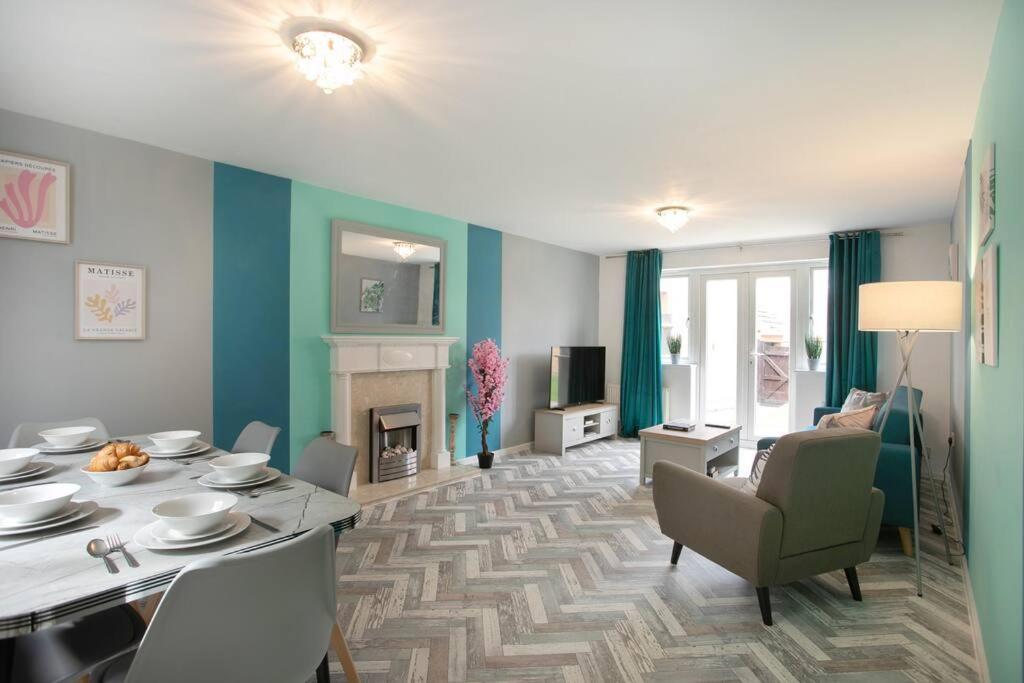 sala de estar con mesa de comedor y sala de estar con paredes azules. en Detached house with BIG monthly discount!, en Peterborough