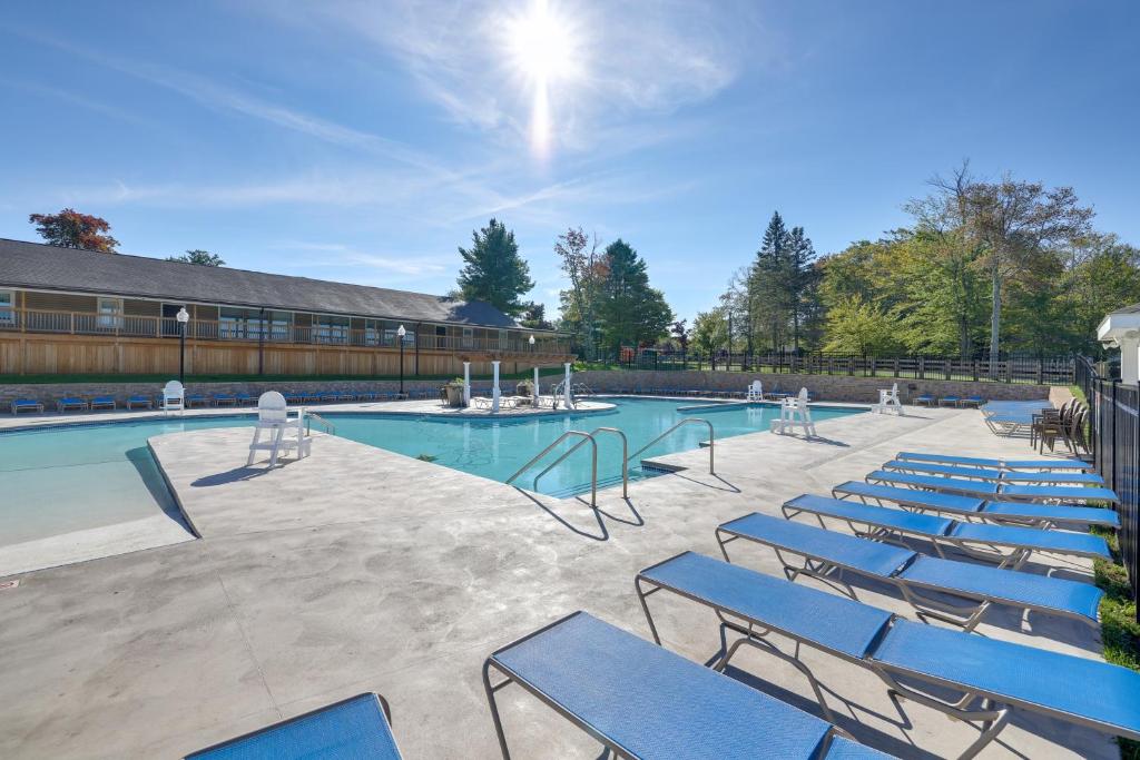 - une piscine avec des chaises bleues dans une cour dans l'établissement Tobyhanna Abode with Golf and Pool Access!, à Tobyhanna