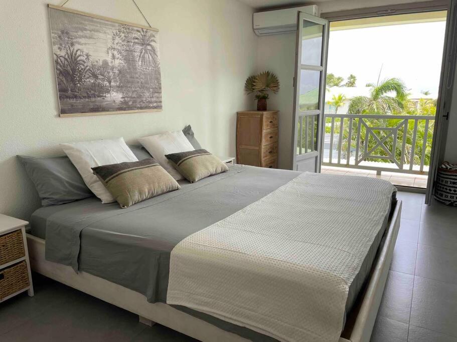a bedroom with a large bed and a balcony at Orient Bay villa in Saint Martin