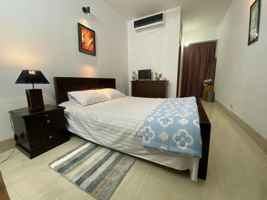 a bedroom with a large bed and a nightstand and a bed sidx sidx sidx at Cozy Ac Private bedroom Gulshan 1 - 6km Airport in Dhaka