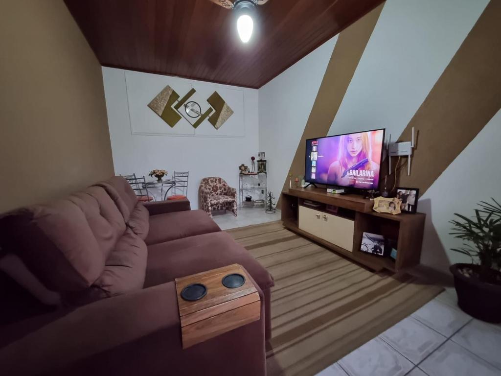 un soggiorno con divano e TV a schermo piatto di Aparecida próxima da Basílica a Aparecida