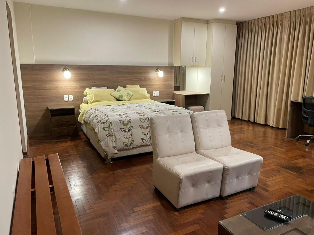 a bedroom with a bed and a chair and a table at FLAT AMOBLADO EN PUEBLO LIBRE - LIMA - PERÚ in Lima