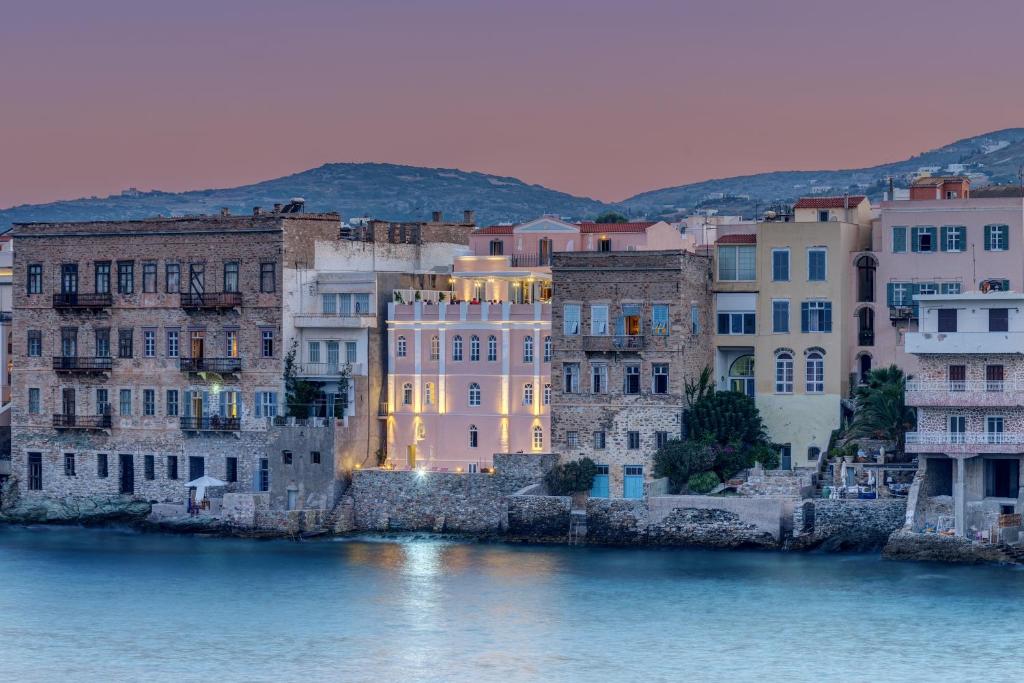 un grupo de edificios junto a una masa de agua en Apollonion Palace, en Ermoupoli