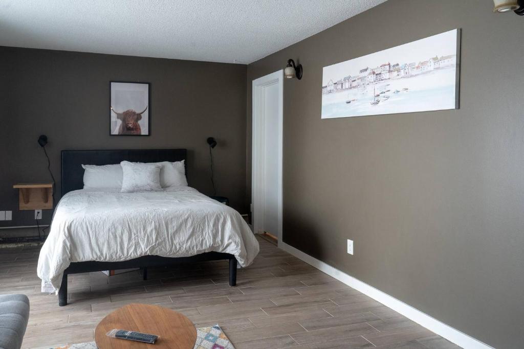 Un dormitorio con una cama y una mesa. en One Bedroom Condo Near Whyte Ave Close to university, en Edmonton