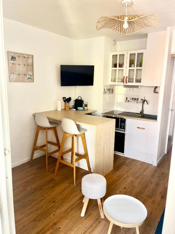 a kitchen with a table and two chairs and a counter at Studio Chaleureux au Cap d’Agde in Cap d'Agde