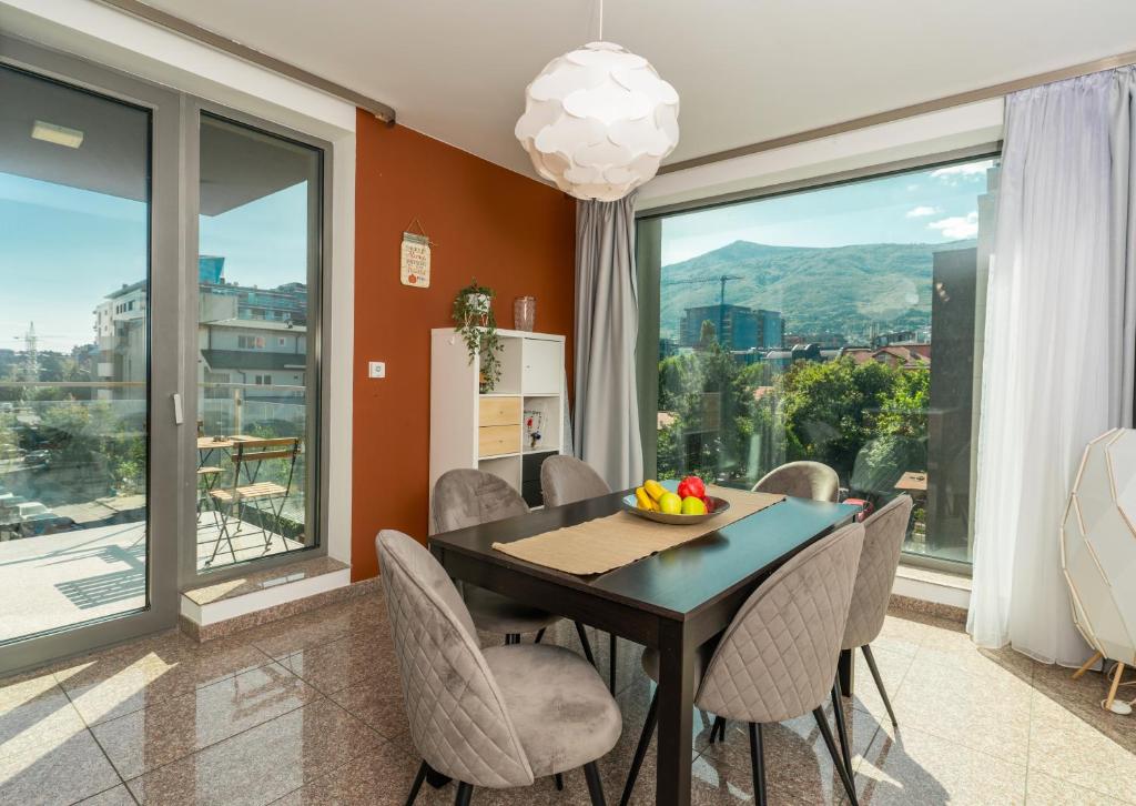 a dining room with a table and chairs and large windows at Vertigo Huge Apartment 2 Bedrooms Balcony Parking in Sofia
