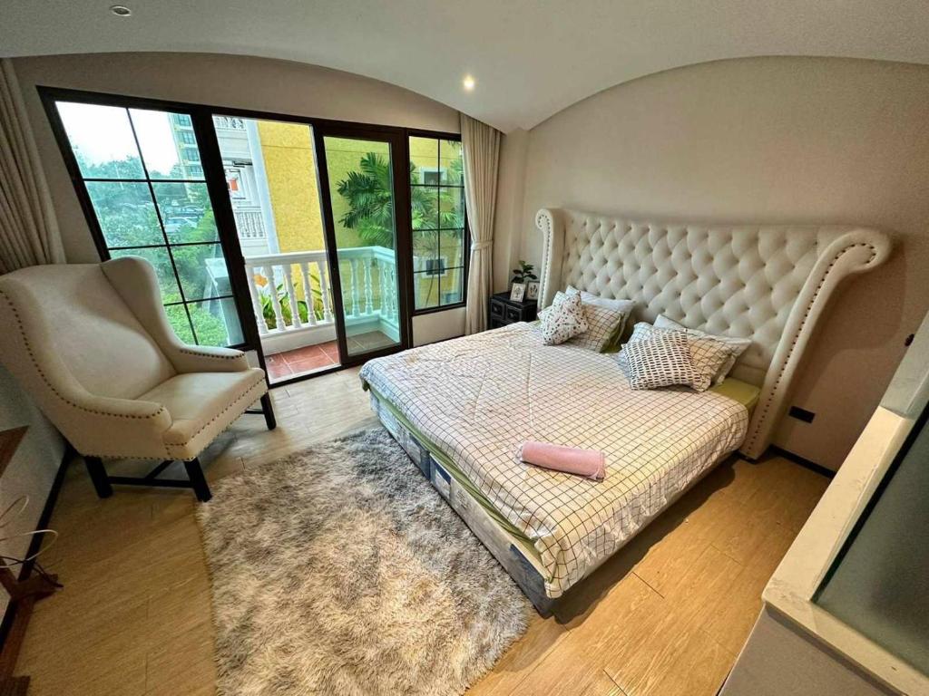 ein Schlafzimmer mit einem großen Bett und einem Stuhl in der Unterkunft Venetian Signature Condo Resort Pattaya in Jomtien Beach