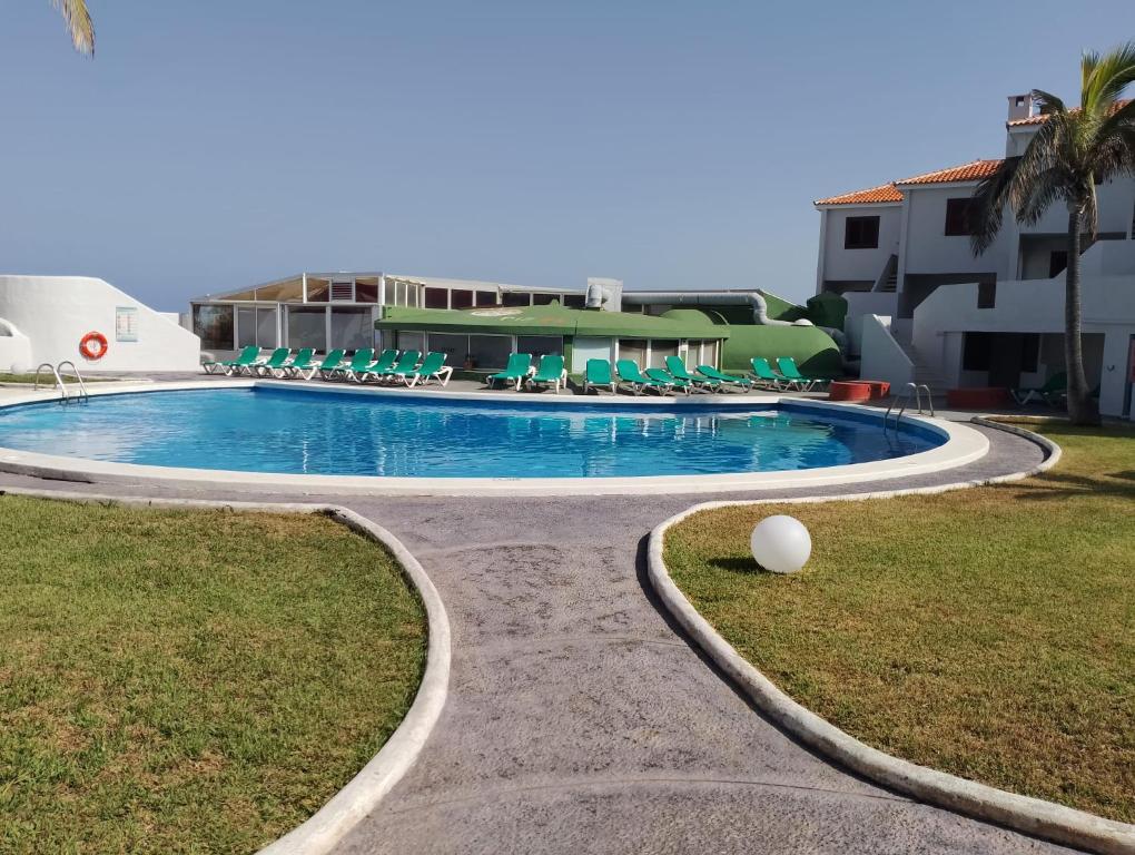 una piscina en un complejo con sillas en Casa Lago Azul 49 en Los Cancajos