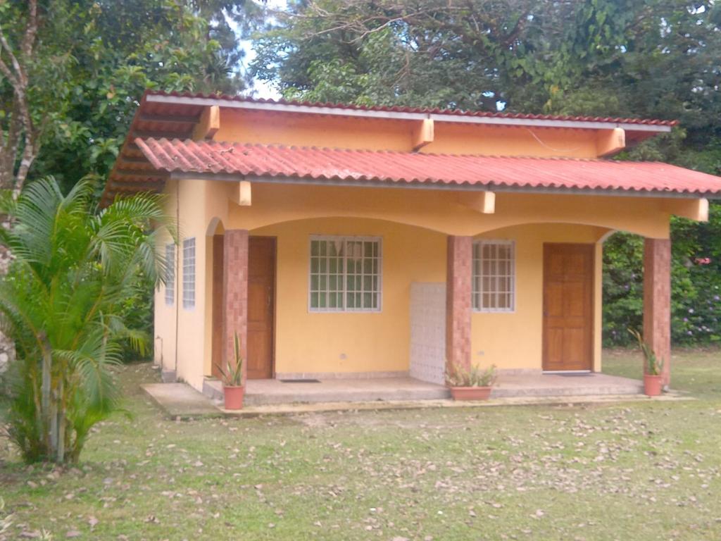 a small yellow house with a red roof at Cabañas El Valle in Antón