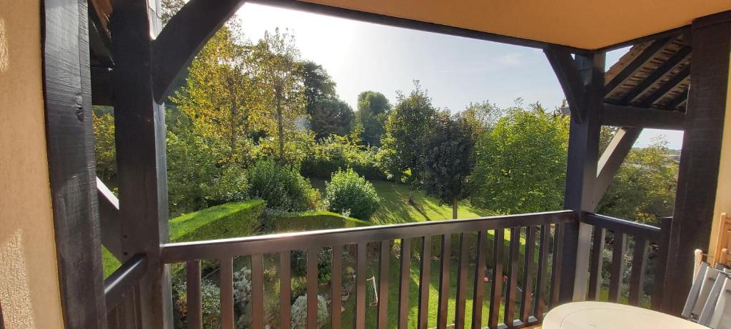 a screened in porch with a view of a garden at Appartement Domaine des Yearlings DEAUVILLE in Deauville
