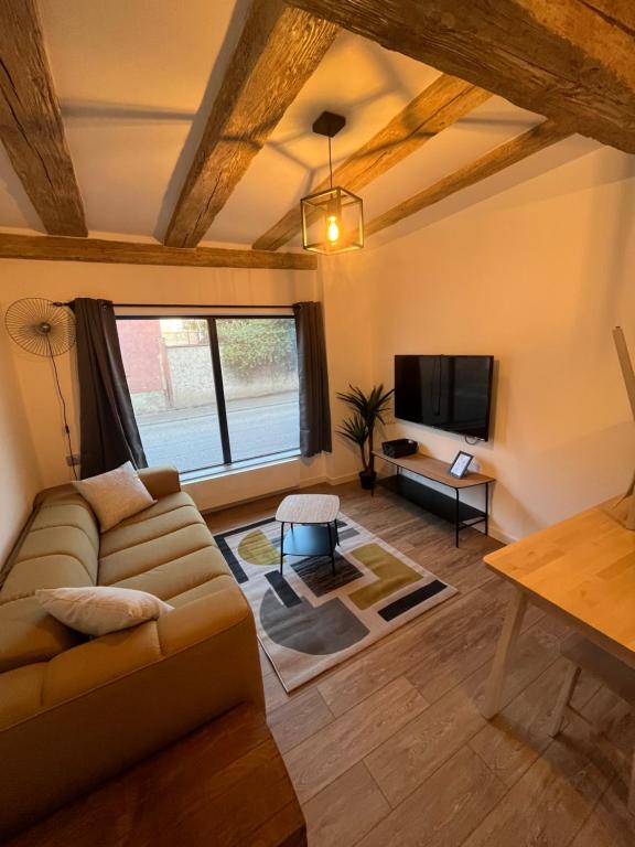 ein Wohnzimmer mit einem Sofa und einem TV in der Unterkunft La Vitrine in Gertwiller